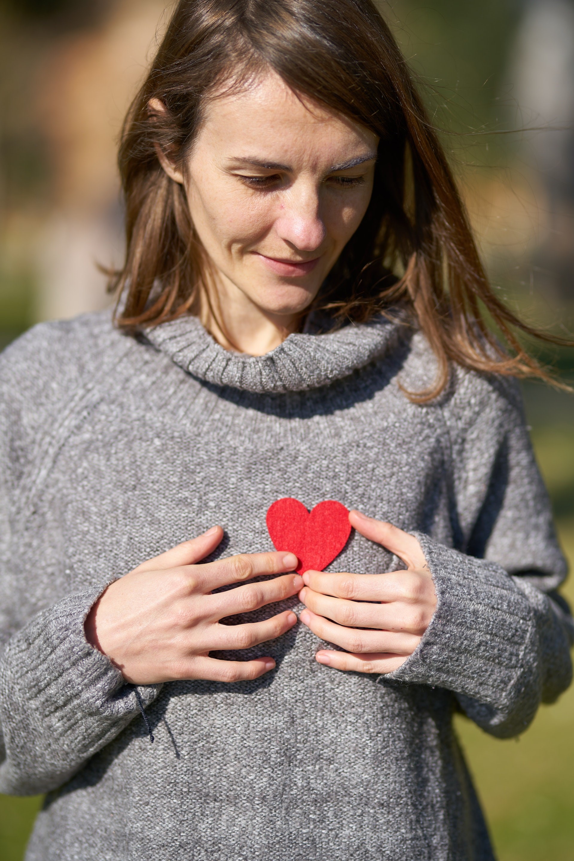 Rødt hjerte på brystet af kvinde. Foto: Pexels.com